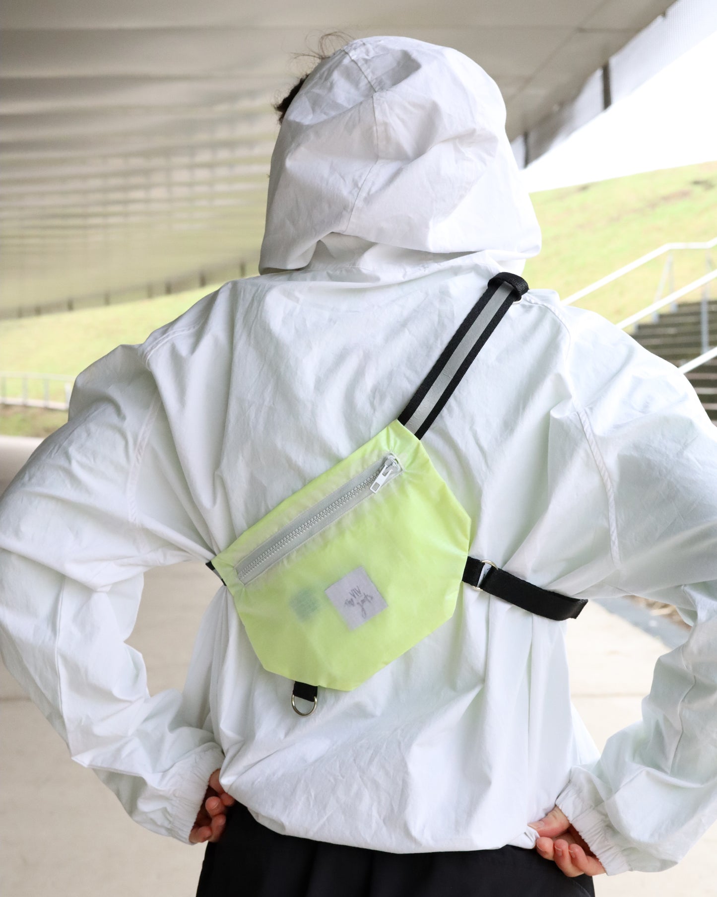 Model wearing neon yellow SPORT.BAG running bag for athletes with reflective T strap