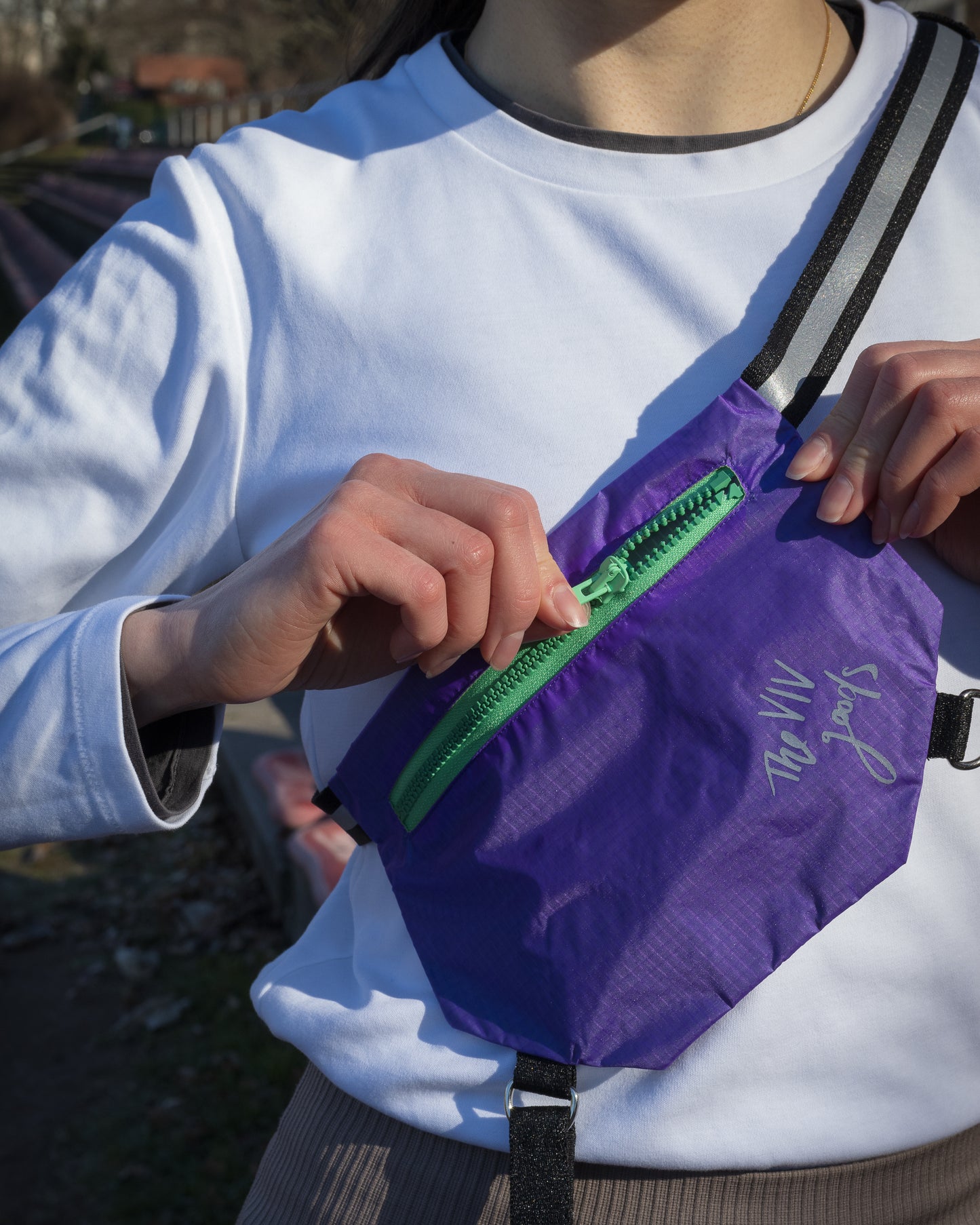 Model wearing SPORT.BAG designed for running. Model unzips the light green front zipper