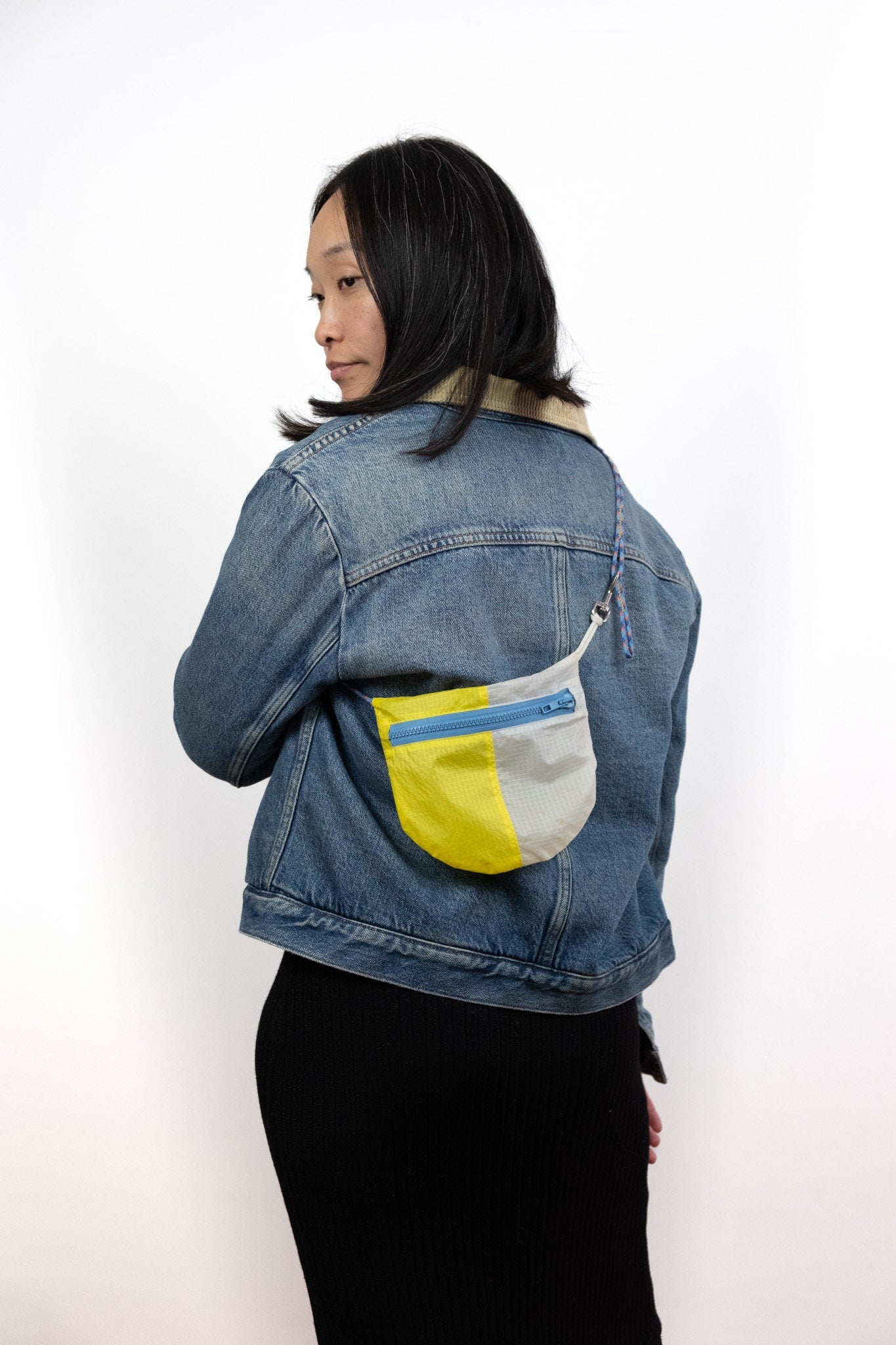 Model wears Billy U.BAG in white and yellow contrast split over her shoulder