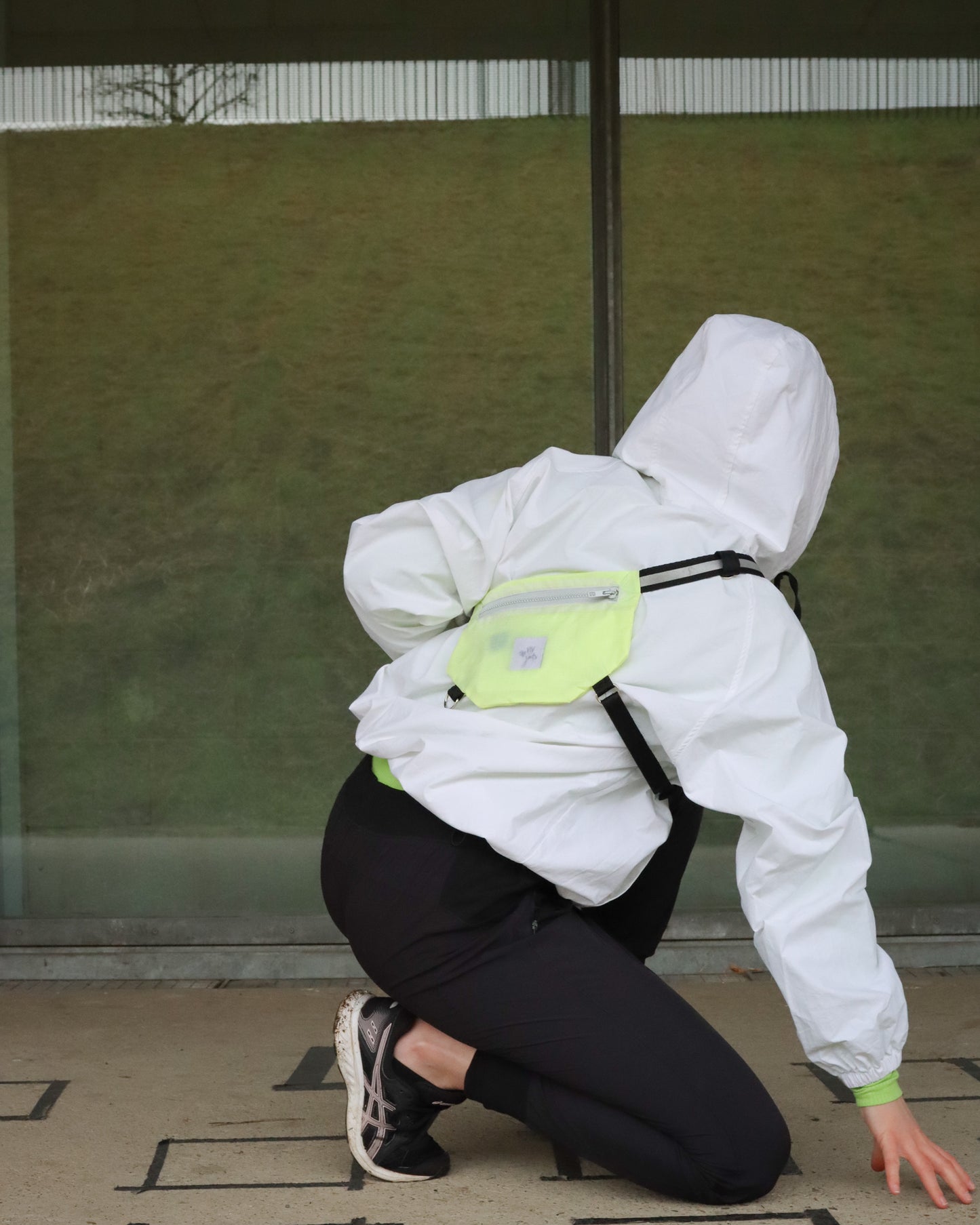 Model wearing neon yellow SPORT.BAG running bag for athletes with reflective T strap