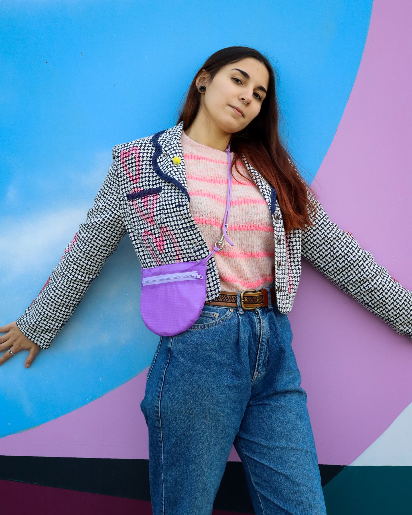 Model wearing crossbody bag in lavender made from recycled rip stop nylon