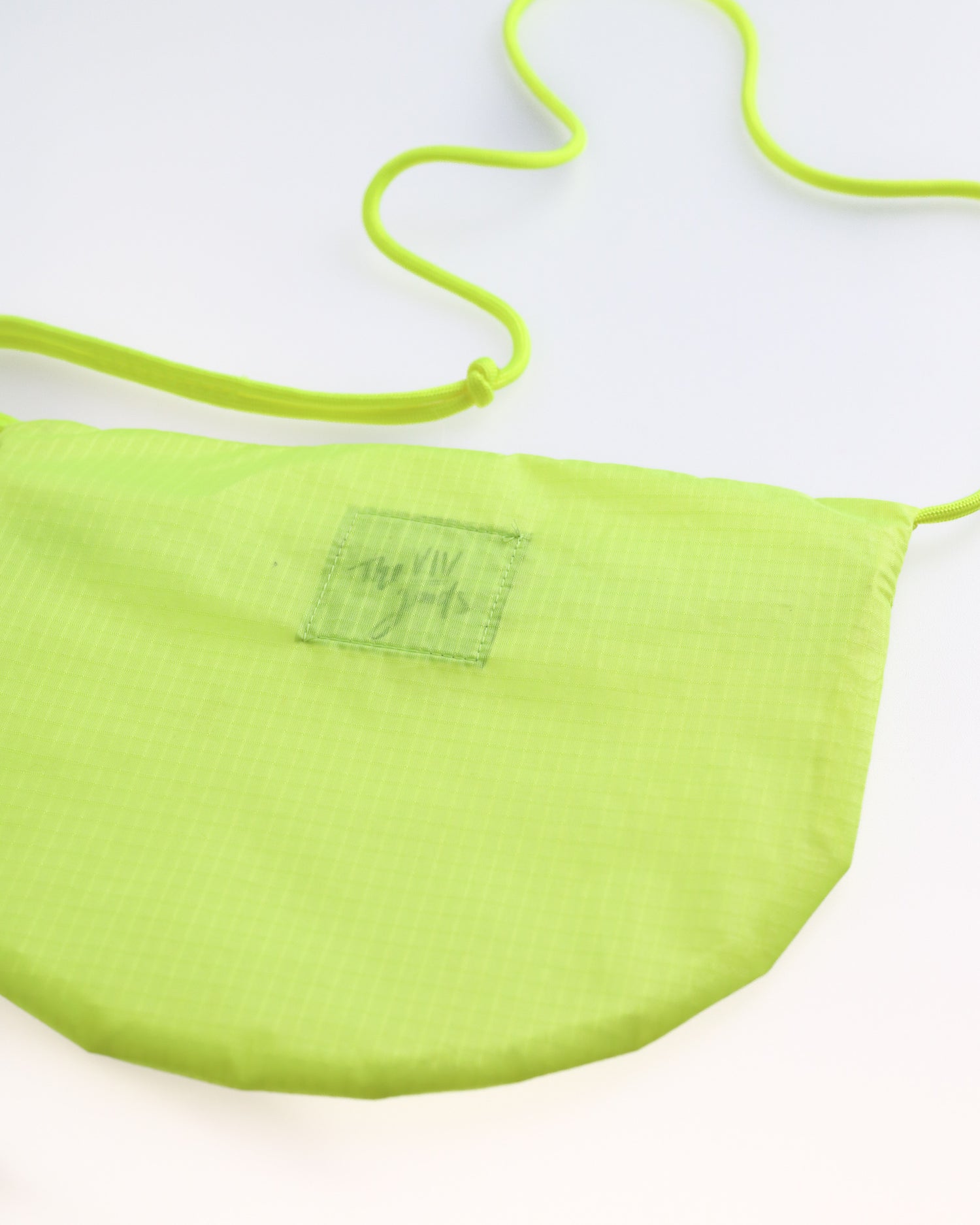 neon yellow cross body bag flat lay shown from back made from vintage paraglider