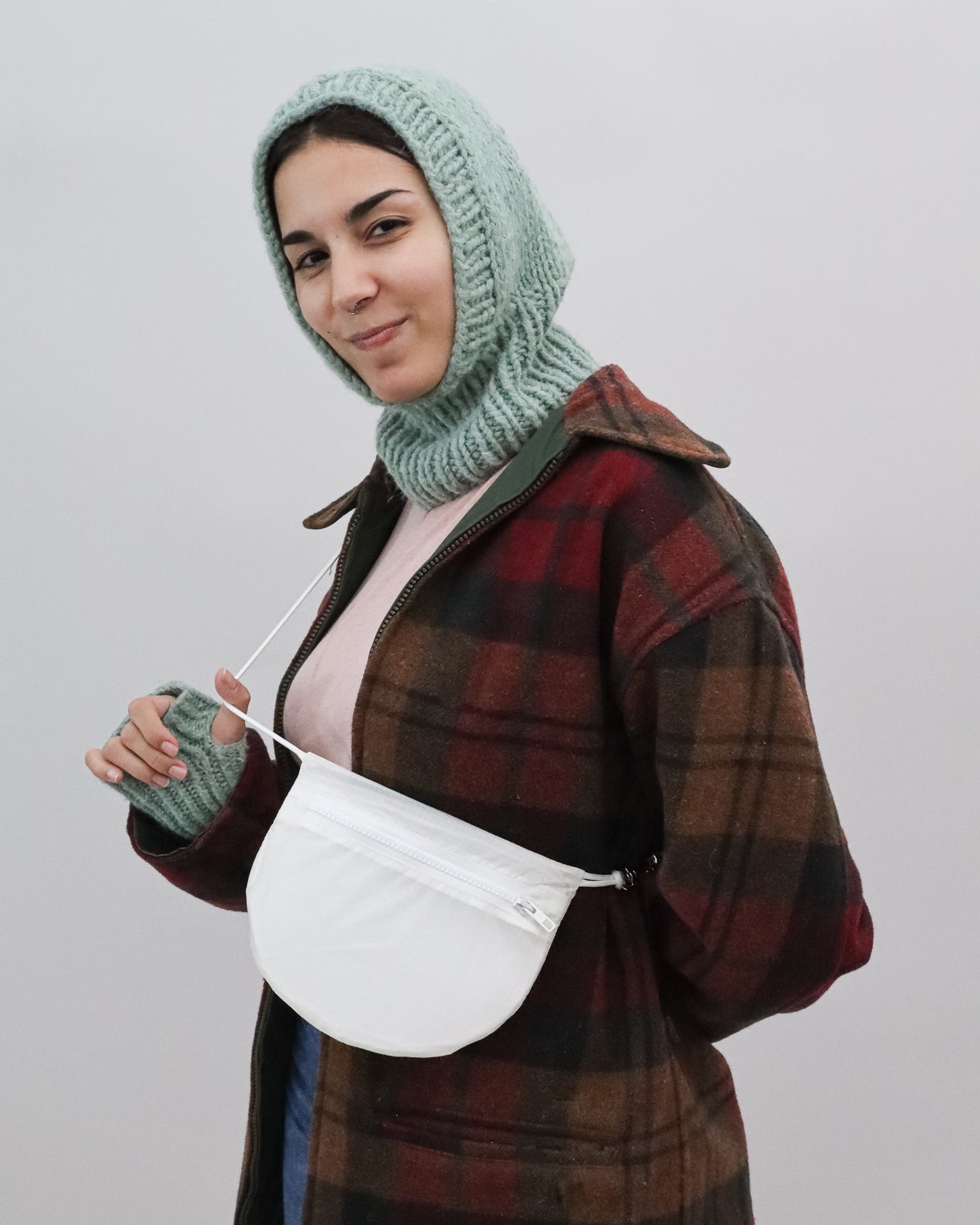 Model wears Cross body bag in white / clear from upcycled nylon cut from vintage paragliders