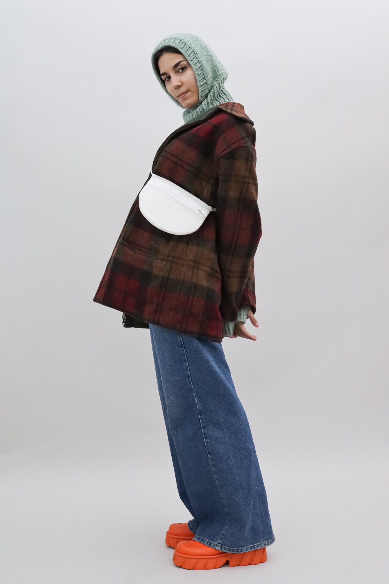 Model wears Cross body bag in white / clear from upcycled nylon cut from vintage paragliders