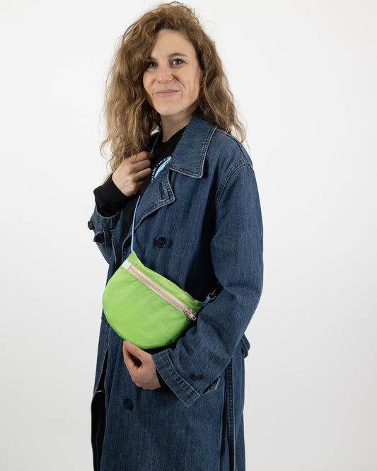 Model wearing U.BAG in lime green and beige and light blue made from retired paragliders