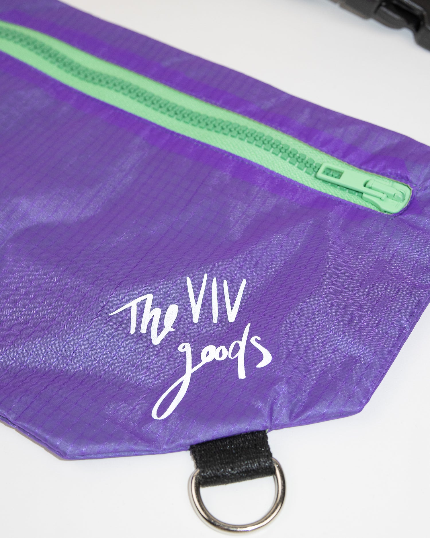 flat lay of the SPORT.BAG designed for runners in purple with a reflective strap and light green zipper